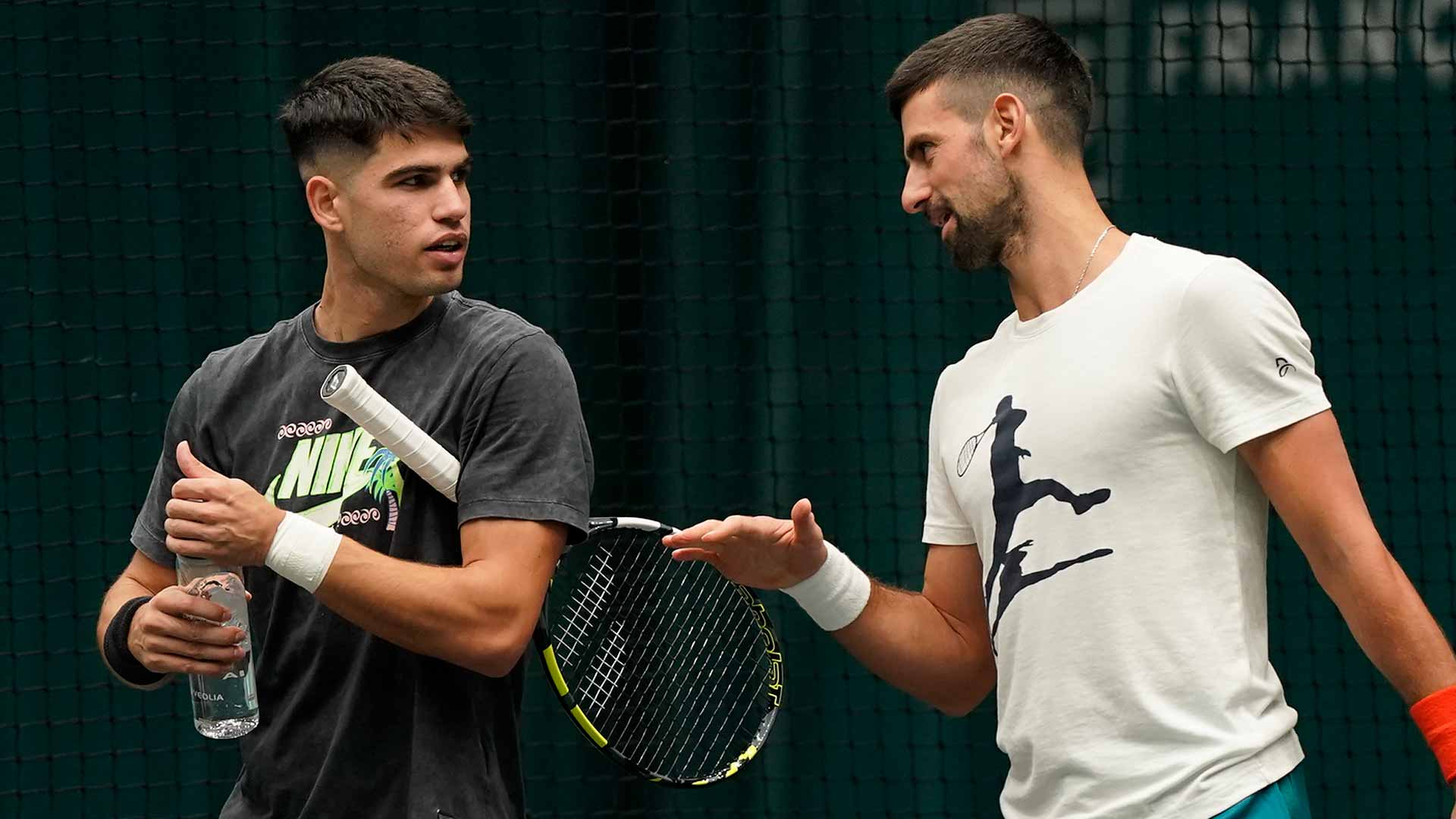 Carlos Alcaraz and Novak Djokovic chat during a break in their practice session on Sunday in Paris.