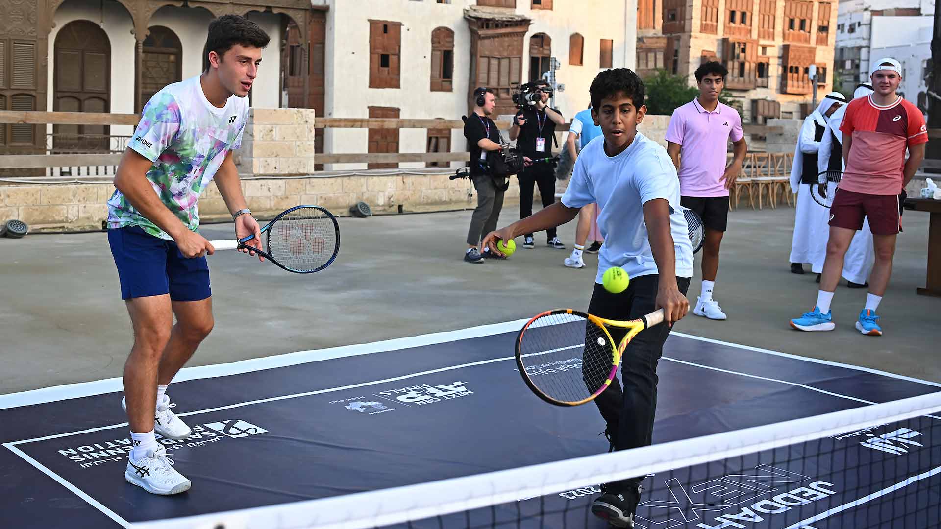 Luca Nardi forma equipo con un tenista junior de Jeddah durante una visita previa al torneo de Al-Balad.