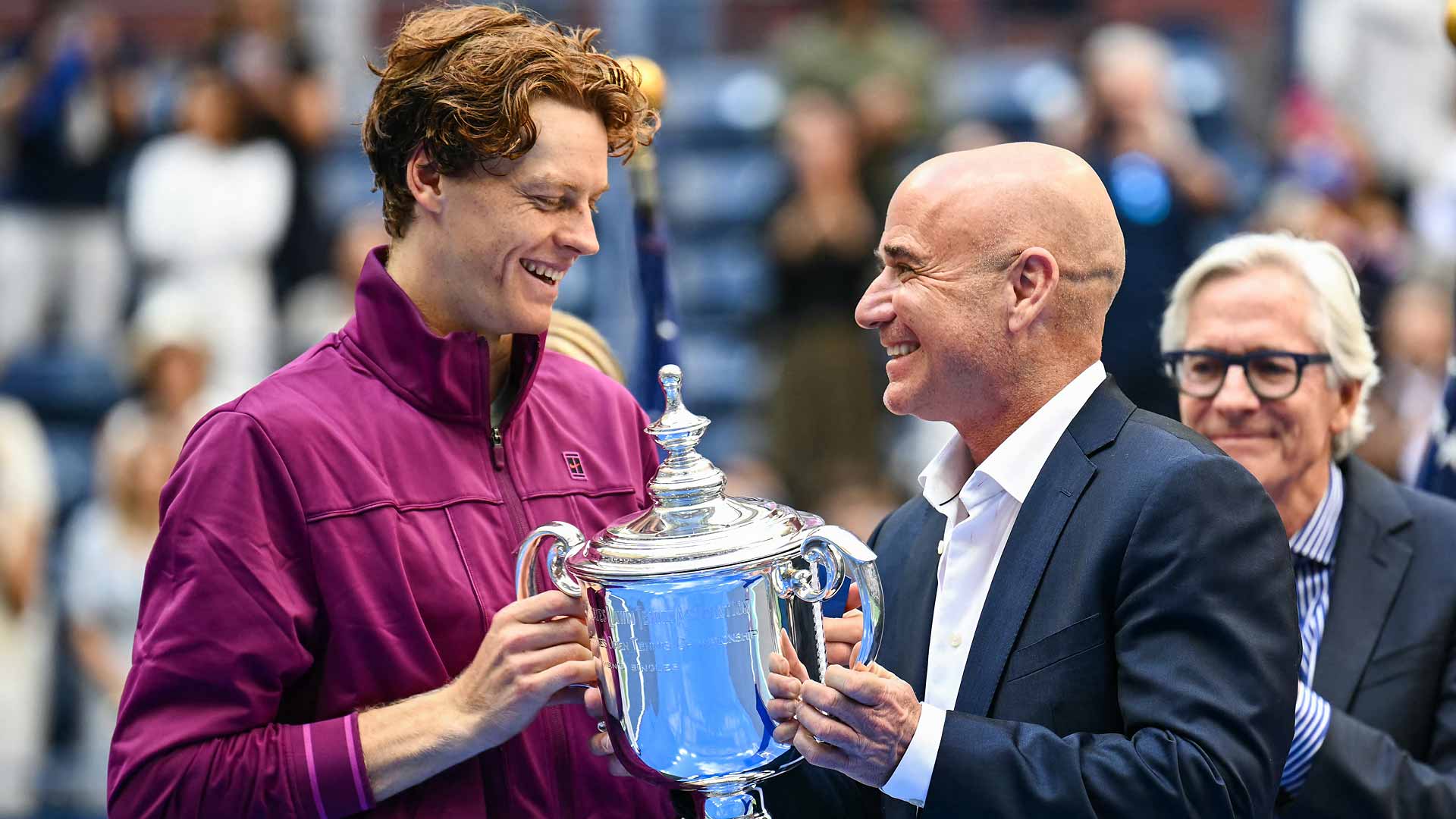 Jannik Sinner accepts the US Open trophy from Andre Agassi on Sunday inside Arthur Ashe Stadium.